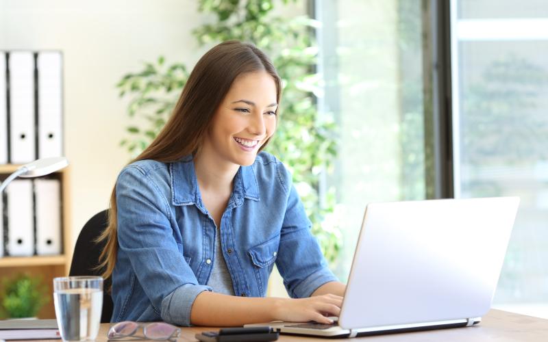 Frau sitzt am Laptop und schreibt Bewerbung